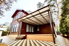 Односкатный навес у дома на металлическом каркасе с поликарбонатной крышей во дворе.