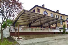 Односкатный навес из поликарбоната на металлическом каркасе у дома