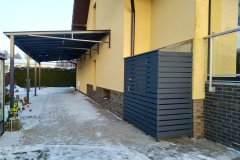 Vienslīpju nojume automašīnai uz metāla karkasa ar polikarbonāta jumtu pie mājas.